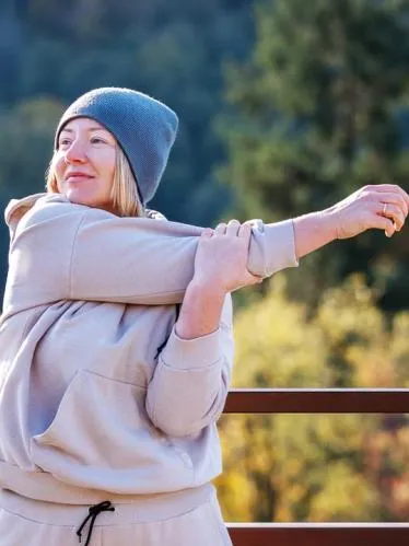 Woman stretching outdoors on Fall day