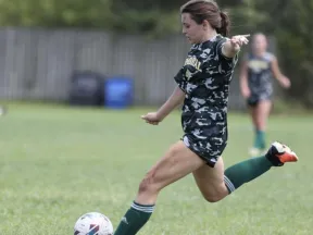 Girl playing soccer on a field.