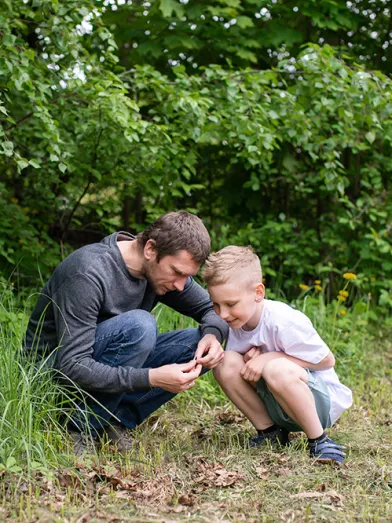 the boy is sitting next to his dad looking at something